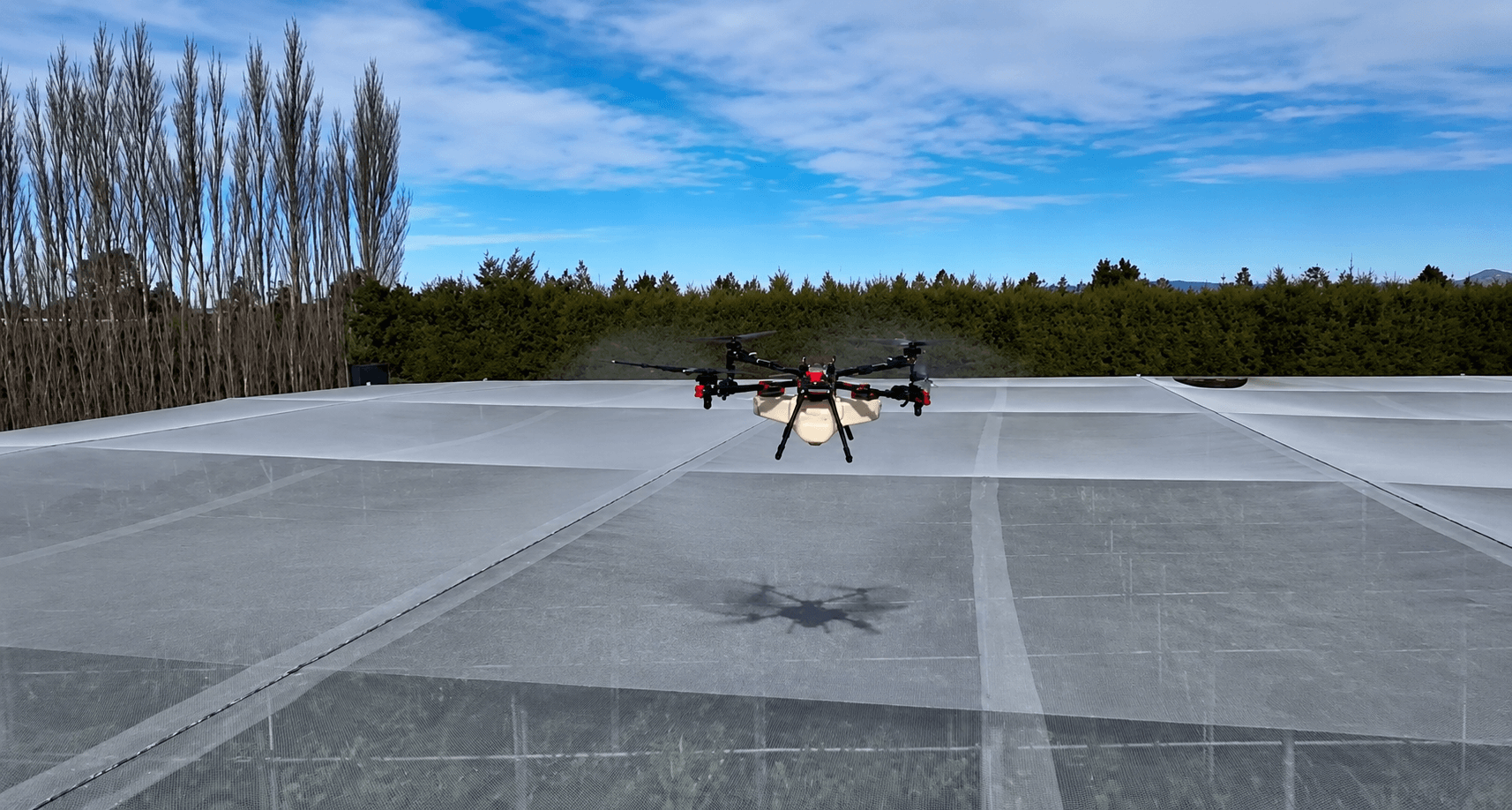 XAG P150 Max agricultural drone spraying orchard hail nets in Tairāwhiti